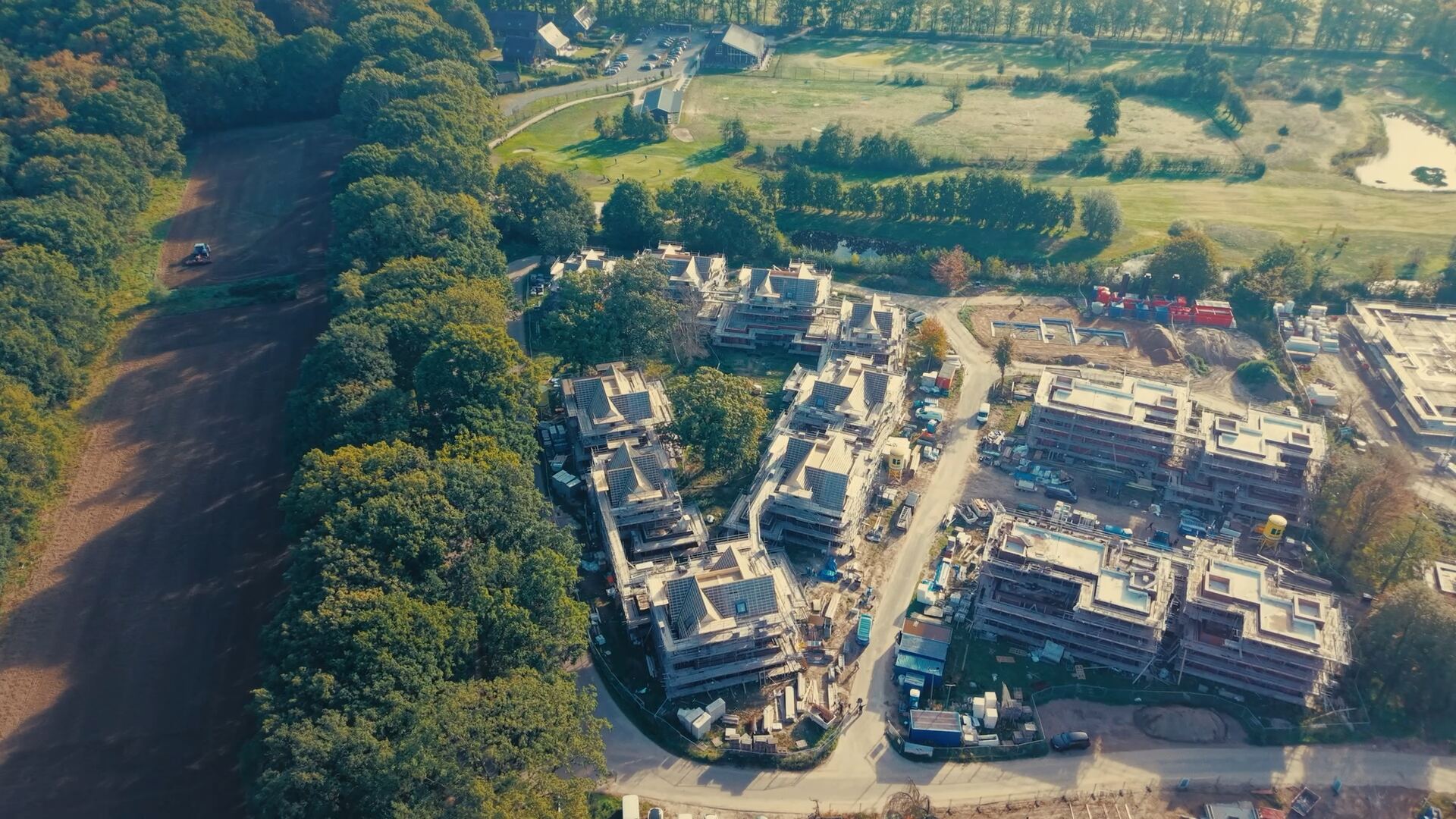 Luchtfoto van de bouwplaats op Coudewater, met woningen in aanbouw tussen oude bomen en weilanden.